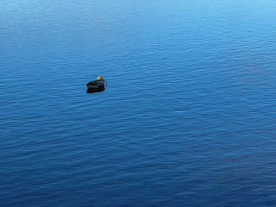 The "Serene Boat on Tranquil Waters - Fine Art Print" features a small black buoy with a yellow top floating alone on calm blue water, capturing the minimalist beauty of water photography.